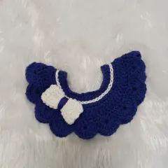 A close-up of the royal blue scalloped collar. The white trim along the neckline and the neatly crafted bow make this a polished and adorable accessory for any child.