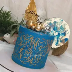 An asymmetrical cake I made for my brother's birthday. This modern design features a bold blue ganache with a gold stenciled pattern, topped with a disco ball, feathers, and an abstract chocolate sail.