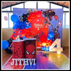 Jithvi's 4th birthday was a web-slinging success with this Spider-Man theme. The decor features a city skyline backdrop, Spider-Man cutouts, and plinths decorated with web patterns and the iconic spider logo.