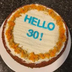 A healthy and delicious carrot and dates cake with cream cheese frosting, perfect for a 30th birthday celebration.