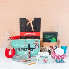 This is my "Modern Day Recovery Kit," a humorous gift for the morning after a big party. It includes fun items like a book of excuses, shot 'golgappas', and fuzzy handcuffs for a laugh.