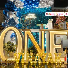 A grand and stylish first birthday party in blue and silver. This setup features a large 'ONE' table, a sequin backdrop, and a beautiful balloon arch for a glamorous look.