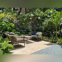 We created this cozy seating nook in an entrance garden in South Mumbai. Surrounded by frangipani trees and lush foliage, it offers a quiet place to sit and enjoy a moment of peace before entering or leaving the home.