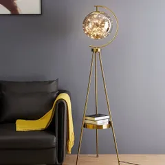This tripod floor lamp is a perfect example of how we blend form and function. The antique brass finish, stable tripod base with a built-in shelf, and a glass globe filled with fairy lights make it a conversation starter that provides warm, ambient lighting.