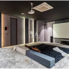 This angle shows the large projector screen and the discreetly integrated speakers. The multi-level seating platform ensures that every viewer has an unobstructed line of sight.