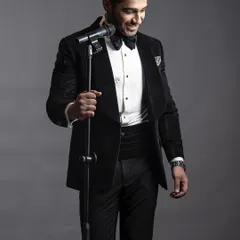 A classic black velvet tuxedo, complete with a pleated shirt and cummerbund. This is the epitome of black-tie elegance, tailored for a flawless fit.
