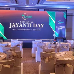 The final setup for the "Jayanti Day" corporate celebration at Shangri-La Bengaluru, featuring a clean stage design and elegant table arrangements.