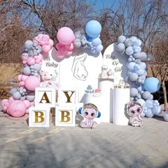 An elegant outdoor baby shower or gender reveal party setup. This design features two arched backdrops, "Boy or Girl" text, and organic balloon garlands in muted pink and blue, along with "BABY" blocks and cute character cutouts.