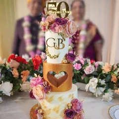 A 50th anniversary is a golden milestone that deserves a truly grand celebration. I designed this elegant, three-tier eggless cake for my own parents' special day, combining classic white and gold with beautiful floral arrangements to create a timeless centerpiece.