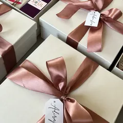 The finished Women's Day gift boxes, elegantly wrapped with a satin ribbon and a personalized, handwritten name tag for each recipient.