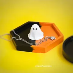 A spooky and cute trinket tray for your Halloween decor. This hexagonal tray is split between black and orange and features an adorable little ghost figurine.