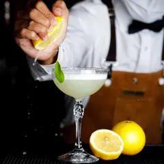 A great cocktail is an experience, and the photo should be too. Here, I captured the exact moment a fresh lemon is squeezed into a gin basil smash, highlighting the craft and freshness that goes into every drink.