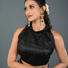 This black halter-neck blouse is fully beaded, giving it a subtle texture and sparkle. It's a sophisticated and modern choice for any occasion.