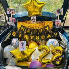 A personalized car boot decoration for a 28th birthday, filled with photos, a 'Happy Birthday' banner, and gold and purple balloons.