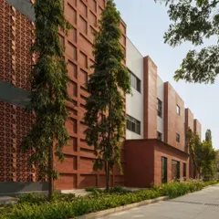 The facade of the Campus Biovet office block showcases our philosophy of using honest, regional materials. A double-walled brick cladding, inspired by the local brick factories of Malur, creates a textured, linear pattern that is softened by the surrounding landscape and tall trees we carefully preserved during construction.