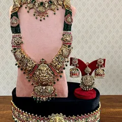 A unique bridal set with a beautiful combination of green beads and antique gold finish. The detailed craftsmanship makes it a truly special piece for a bride's big day.