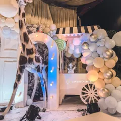 A life-sized giraffe prop stands next to a custom-built candy cart, adding a touch of whimsy and scale to this carnival setup.