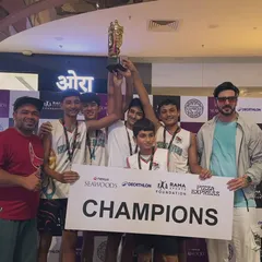 The U-14 boys team hoisting their championship trophy high. This victory at the Seawoods Nexus mall tournament was a result of their collective effort and strategic play.