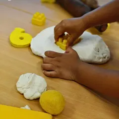 Pressing a block into soft dough is a powerful lesson in cause and effect. This simple action strengthens hand muscles for writing, develops spatial awareness, and encourages focused, creative exploration without a "right" or "wrong" outcome.