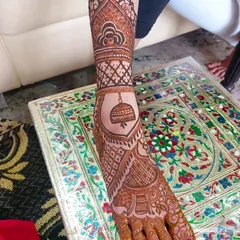 I love adding unique elements, like this 'jhumka' (earring) motif hanging from the ankle band. It adds a playful and traditional touch to this leg henna design.