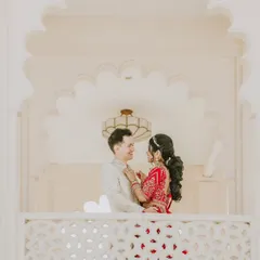 An intimate portrait of Spencer and Namrata framed by the elegant white arches of their palace wedding venue.