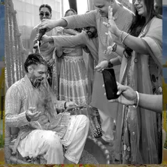We believe in capturing both the color and the emotion. This black and white shot focuses on the groom's reaction as he is doused with water during his Haldi, highlighting the fun and chaos of the moment.
