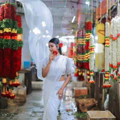 A stunning shot of a model in a white organza saree, captured in the vibrant setting of a Bangalore flower market. I love creating unique concepts for traditional wear.