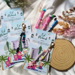 A beautiful flat lay of our Eid gift collection, featuring our Eidi Mubarak cards, personalized keychains, and custom name pens.