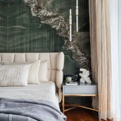 A closer look at the master bedroom's headboard wall, where fluted green marble creates a stunning textural and visual anchor. The wingback-style upholstered headboard and minimalist bedside lighting complete this picture of modern luxury.