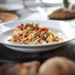 A beautifully plated dish of tagliatelle with a fresh tomato sauce. This is the delicious result of our hands-on pasta making sessions.