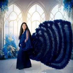 A fairytale moment in blue. This elaborate gown with a dramatic ruffled train creates a stunning visual against a dreamy, palatial backdrop for a fine-art maternity look.