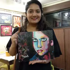 A student proudly holding her finished portrait. Using a palette knife and bold colors, she has created a piece full of emotion and strength. This is what we aim for, an artwork that speaks for you.