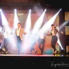 The magic of stage lighting. A well-lit performance can transform the entire mood. Here, the Motley Crew performs a group number, using spotlights to create a dramatic and professional effect.