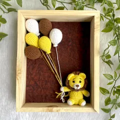 A sweet lion cub holding yellow, brown, and white balloons. This framed art is a unique way to decorate a jungle-themed nursery.