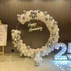 Celebrating a silver jubilee is a momentous occasion. For this 25th wedding anniversary, I designed a clean and sophisticated circular balloon arch in white and silver, paired with a "Happy Anniversary" neon sign and large, illuminated "25" numbers for a perfect photo opportunity.