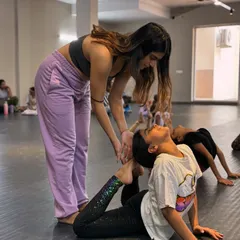 We believe in nurturing every dancer's potential. Here, one of our instructors provides gentle, hands-on guidance to help a young student safely deepen her backbend and improve her flexibility.