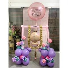Welcoming Baby Vedika with this unique and intricate sculpture. A tiny baby balloon sits on a swing adorned with flowers, all held up by balloon columns, creating a truly special and handcrafted welcome gift.