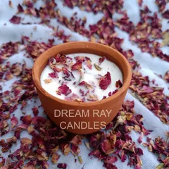 I create candles in various containers, including these rustic terracotta jars. Pictured is a rose-scented soy candle topped with dried rose petals, combining natural aesthetics with beautiful aromatherapy.