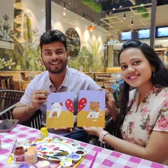 A couple shows off their adorable matching cat paintings. Our guided art dates are perfect for creating a shared masterpiece, even if you're a total beginner.