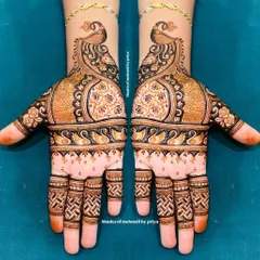 This design combines bold peacock figures with delicate floral patterns and fine line work, creating a balanced and beautiful look for the bride.