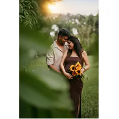 A sun-kissed portrait of a couple in a beautiful garden setting, holding sunflowers that add a touch of warmth and happiness.