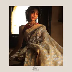 This shot, styled for a handloom brand, is all about texture and tradition. The beautiful Banarasi saree is the hero, complemented by a rich maroon blouse and a statement choker. The window light creates a soft, painterly effect, embodying timeless Indian elegance.