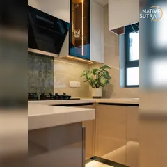 This corner of the renovated kitchen highlights the practical design, with ample counter space and well-placed power outlets. A potted plant adds a touch of green, bringing life to the minimalist design.