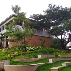 This project for a yoga school demonstrates our ability to work with challenging topography. We designed a series of terraces with curved retaining walls to create usable green spaces on a natural slope, integrating the building with the hillside.