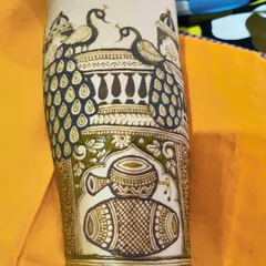 A detailed look at an armband design featuring dancing peacocks on a balcony and a dhol drum motif below.