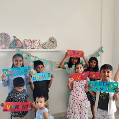 A group of happy kids showing off the amazing nameplates they made at a birthday party. Each one is so different and creative!