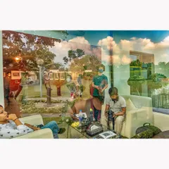 A complex reflection at a gallery in Delhi, merging the people inside with the sky and landscape outside. This photograph captures the life of the gallery, both within its walls and in the world reflected on its surface.