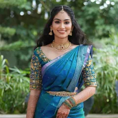 A happy, smiling portrait of the bride. For her engagement, we chose a half-up, half-down hairstyle with soft waves, which perfectly complements her elegant saree and soft glam makeup.