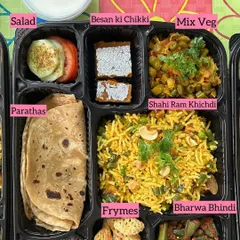 A closer look at one of my special Jain meal trays. This one features Shahi Ram Khichdi, Mix Veg, Bharwa Bhindi, Parathas, and even a Besan ki Chikki for a sweet treat, all made without onion or garlic.