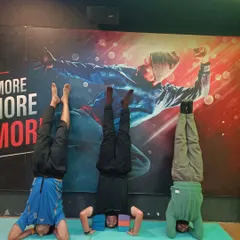 Another group of students mastering the headstand. This inversion improves circulation, calms the mind, and builds significant upper body and core strength.